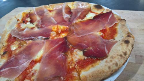 a pizza with ham on it on a table at Antichi Feudi Dimora D'Epoca in Teggiano