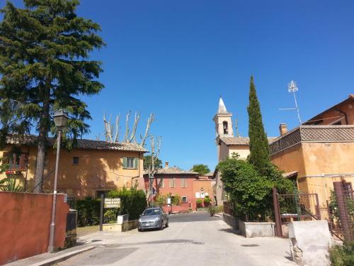 a car parked on a street with a church tower at Hotel Tempio di Apollo in Olgiata
