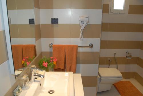 a bathroom with a toilet a sink and a bath tub at Seabel Rym Beach Djerba in Taguermess