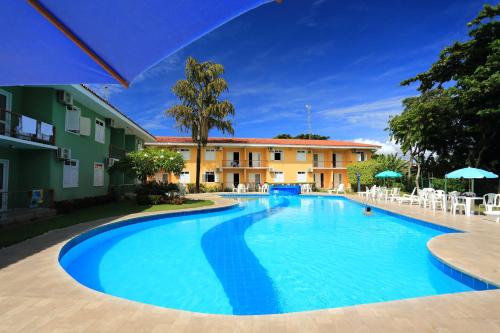 a large swimming pool in front of a building at Boulevard da Praia Apart Hotel in Porto Seguro