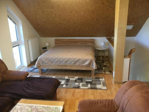 um pequeno quarto com uma cama e um sofá em Ferienwohnung Fischer em Dietmannsried