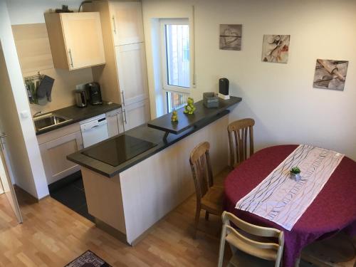 a kitchen with a table and a small kitchen with a table and chairs at Ferienwohnung Fischer in Dietmannsried