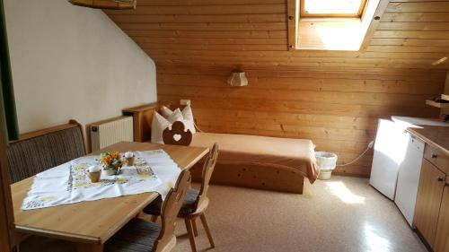 ノイシュティフト・イム・シュトゥーバイタールにあるGasperlerhofのベッド、テーブル、キッチンが備わる小さな客室です。