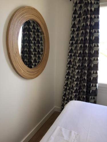 a bedroom with a mirror and a window at Hotel La Casa in Le Barcarès