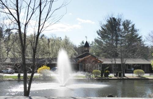 a fountain in a pond in front of a building at Village Inn - Blowing Rock in Blowing Rock