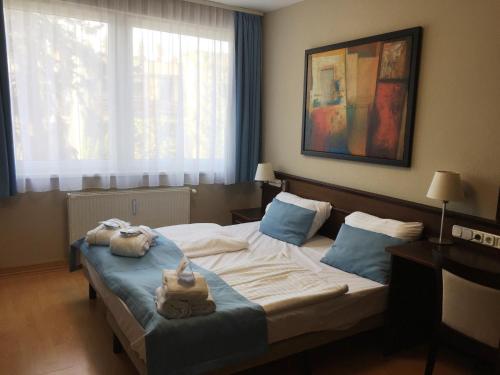 a hotel room with a bed with towels on it at Holiday Club Füred in Balatonfüred