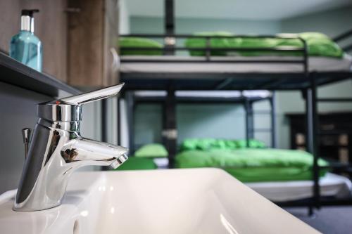 a bathroom sink with a faucet next to a bunk bed at YHA Keswick in Keswick