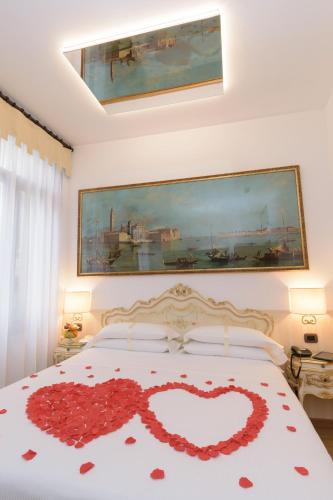 a bedroom with a bed with a heart decoration on it at UNAHOTELS Ala Venezia-Adults 16 in Venice
