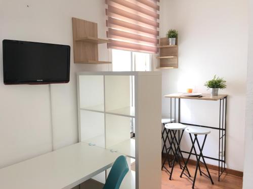 een kamer met een bureau en een tv aan de muur bij Hôtel du Petit Louvre in Nice