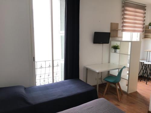 een slaapkamer met een bed, een tafel en een bureau bij Hôtel du Petit Louvre in Nice