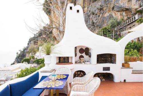 a patio with a table and chairs and a fireplace at La Casa di Peppe in Positano