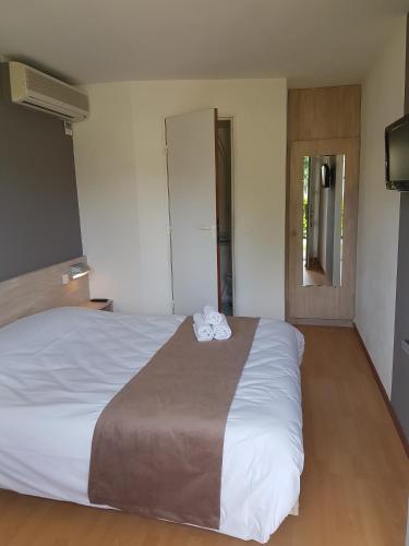 a bedroom with a large white bed in a room at Fasthôtel - Saint Emilion Est in Montcaret