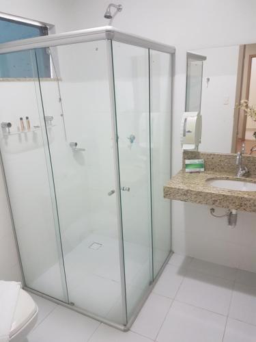 a glass shower in a bathroom with a sink at Hotel Porto Madeira in Porto Velho