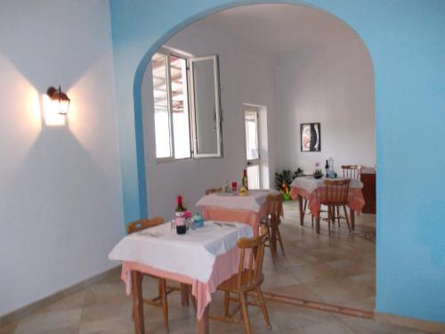 una sala da pranzo con tavoli e sedie e una finestra di B&B Porta di Suso Camerota a Camerota