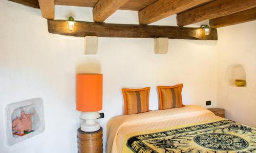 a bedroom with a bed with an orange lamp at Al Mulino in Fregona