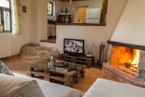 a living room with a tv and a fireplace at Lithari in Kámboi