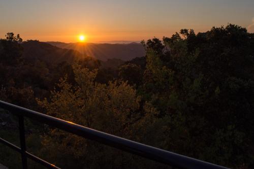 a sunset from the top of a mountain with trees at Lithari in Kámboi