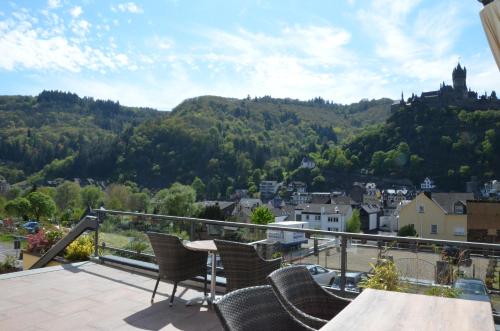 a balcony with chairs and a view of a city at Flair Hotel am Rosenhügel - Garni in Cochem