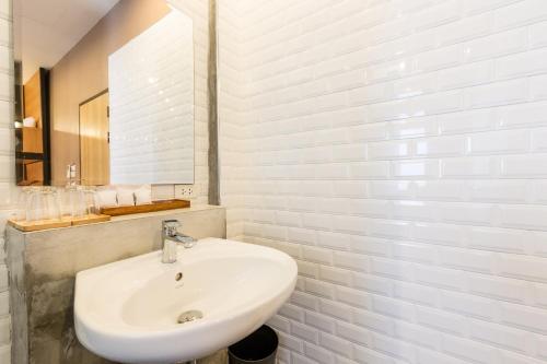 a white bathroom with a sink and a mirror at Srisuksant Square in Krabi town