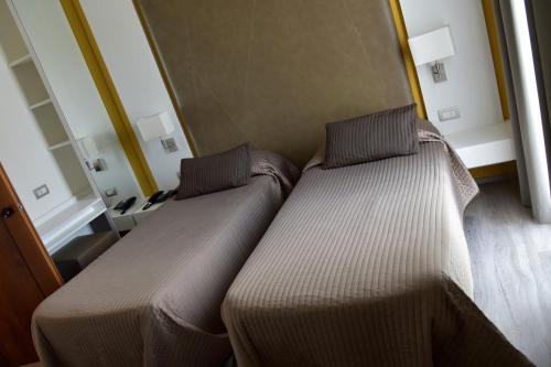 two beds sitting next to each other in a room at Hotel Giulietta Romeo in Lazise