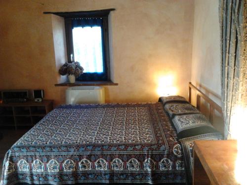 a bedroom with a bed and a window at Il Sartù in Dogliani