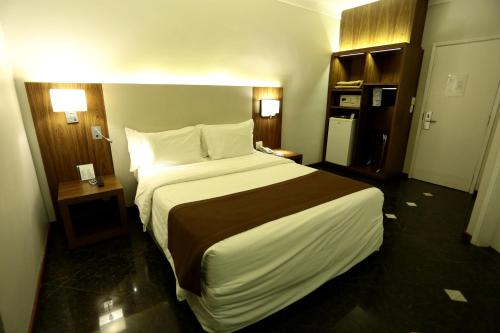 a bedroom with a large bed in a hotel room at Oasis Plaza Hotel in Ribeirão Preto