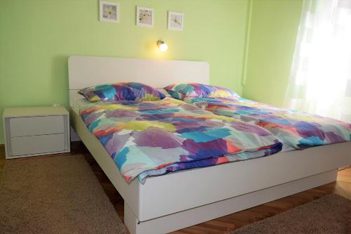 a bed with a colorful comforter in a bedroom at Apartments Rab City View in Rab