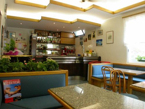 a restaurant with tables and chairs and a bar at Albergo Aquila in Lido di Jesolo