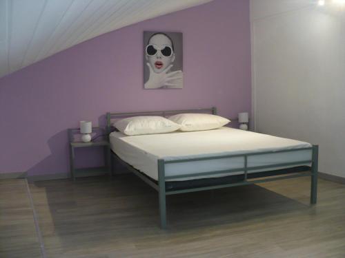 GrillonにあるGITE DE LA GARÈNEのベッドルーム1室(壁にマスク付きのベッド1台付)