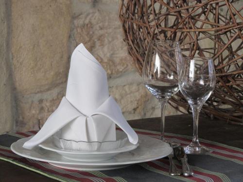 a white hat on a plate with two wine glasses at Weinstadt Hotel - das Original in Weinstadt
