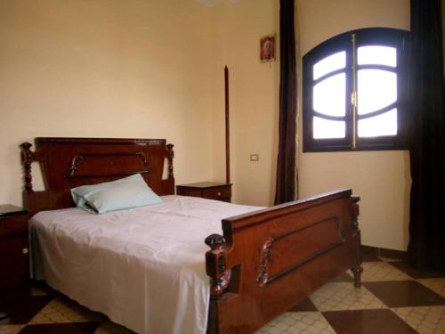 a bedroom with a large bed with a window at Blue Sky Apartments in Luxor