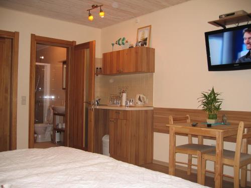a bedroom with a bed and a tv and a table at Molo Užeiga Inn in Klaipėda