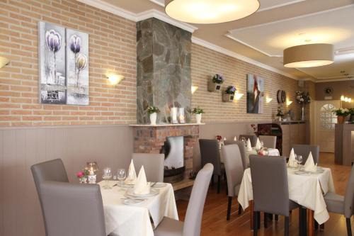 Hotel Kodde في آختيكيركي: غرفة طعام مع طاولات وكراسي ومدفأة