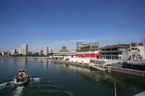 a small boat in the water near a pier at Hôtel Huatian Chinagora in Alfortville