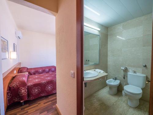 uma casa de banho com um sofá vermelho, um WC e um lavatório. em Hotel Golden Sand em Lloret de Mar