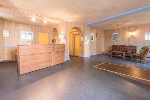 Cette grande chambre comprend une table de ping-pong et des chaises. dans l'établissement City Résidence Termalia, à Capvern