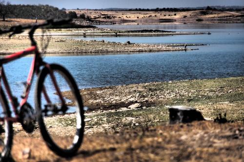 a bike parked next to a body of water at Os 5 Sentidos in Mourão