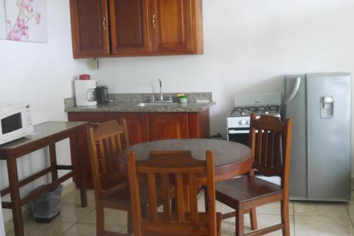 a kitchen with a table and a stainless steel refrigerator at Fosters West Bay Resort in West Bay