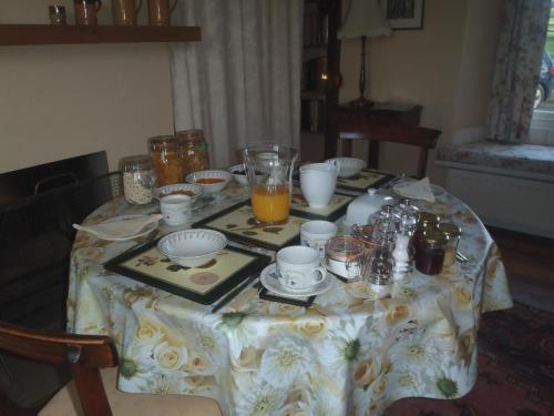a table with a table cloth with dishes and drinks on it at Kipps Farm in Great Torrington