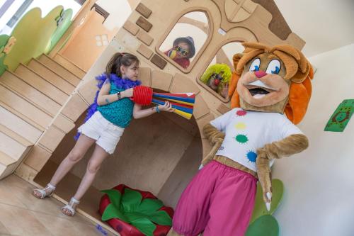 a young girl standing next to a girl dressed in a mascot at Grande Baia Resort & Spa in San Teodoro