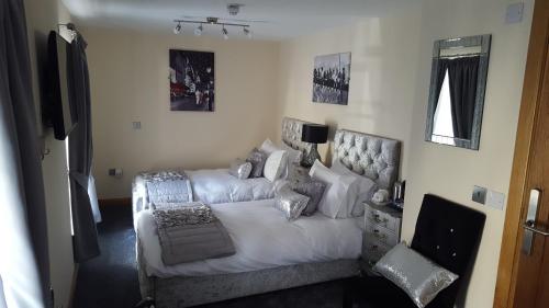 a bedroom with a white bed and a couch at Star Inn Rooms in Ardersier