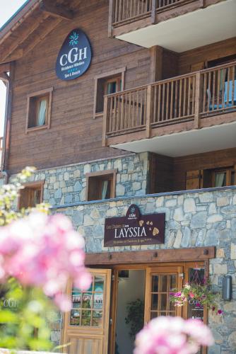 un bâtiment avec une enseigne devant lui dans l'établissement CGH Résidence Boutique Les Chalets De Laÿssia, à Samoëns