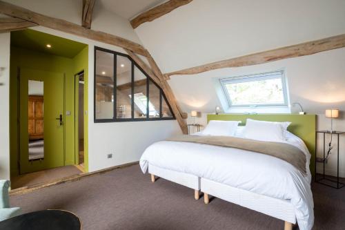 a bedroom with a large bed and a window at Le Clos du Verger in Levernois