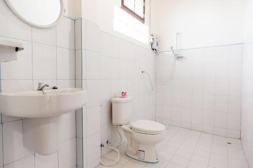 a white bathroom with a sink and a toilet at Zuela Guesthouse in Louang Namtha