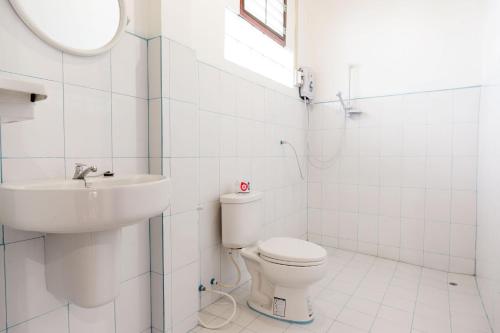 Baño blanco con lavabo y aseo en Zuela Guesthouse, en Luang Namtha