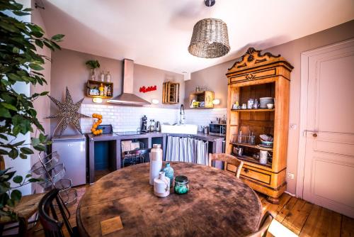 a kitchen with a wooden table in a room at Les chambres de Lily in Carresse