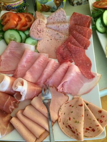 a plate of food with meats and vegetables on a table at Pension Karner in Mittenwald