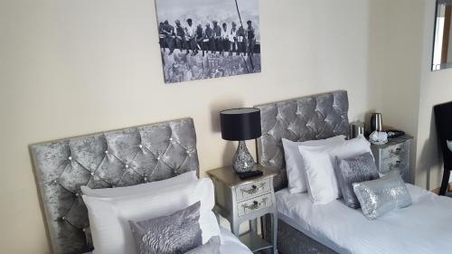 a bedroom with two beds and a picture on the wall at Star Inn Rooms in Ardersier