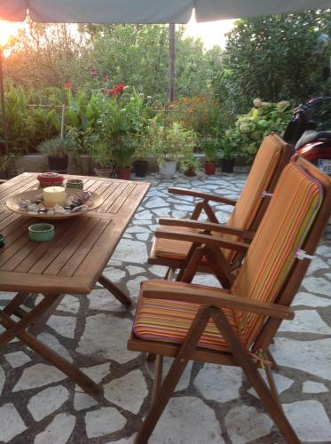 two wooden chairs and a table on a patio at Nontas Home in Kalamitsi