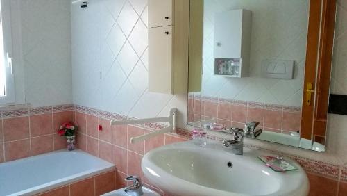 a bathroom with a sink and a mirror and a tub at Mattoni Nel Verde in Casal Palocco